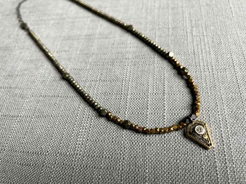 top view of antique Art Deco pendant hung on metallic bead choker