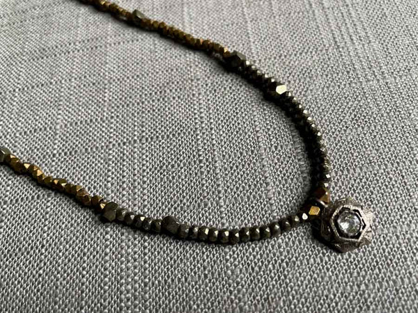 closeup of antique Art Deco pendant with diamond hung on metallic bead choker