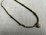 top view of antique Art Deco pendant with diamond hung on metallic bead choker