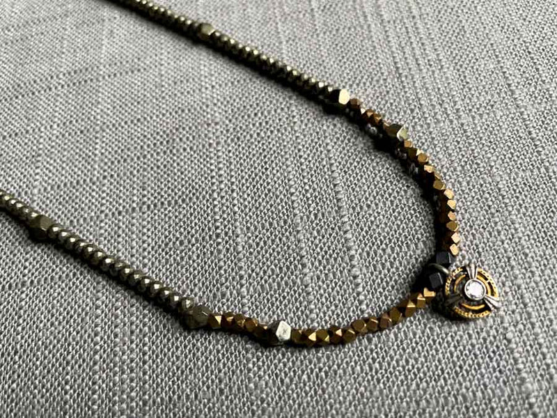 closeup of antique Art Deco pendant with diamond hung on metallic bead choker