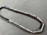 top view of gemstone bead necklace comprising white pearl, neutral shadow quartz and exotic wood