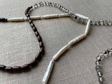 closeup of gemstone bead necklace comprising white pearl, neutral shadow quartz and exotic wood