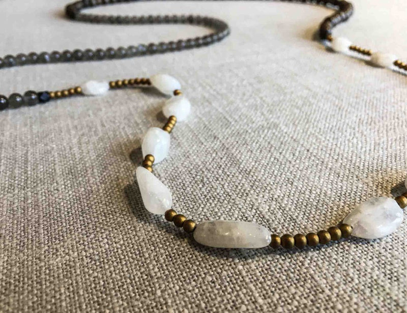 closeup of gemstone bead necklace comprising white moonstone, grey moonstone, exotic wood and gold hematite