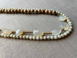 side view of gemstone bead necklace comprising white chalcendony, off-white Siberian moonstone and exotic wood