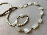 closeup of gemstone bead necklace comprising white chalcendony, off-white Siberian moonstone and exotic wood