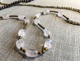 closeup of gemstone bead necklace comprising pink rose quartz, white siberian moonstone, exotic wood and matte gold