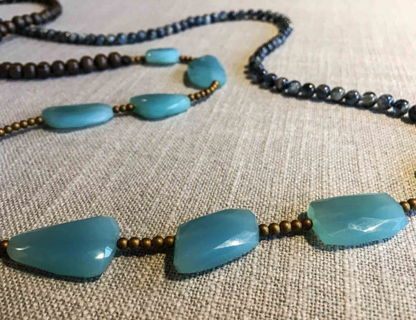 closeup of gemstone bead necklace comprising blue chalcedony, blue kyanite, exotic wood and gold hematite