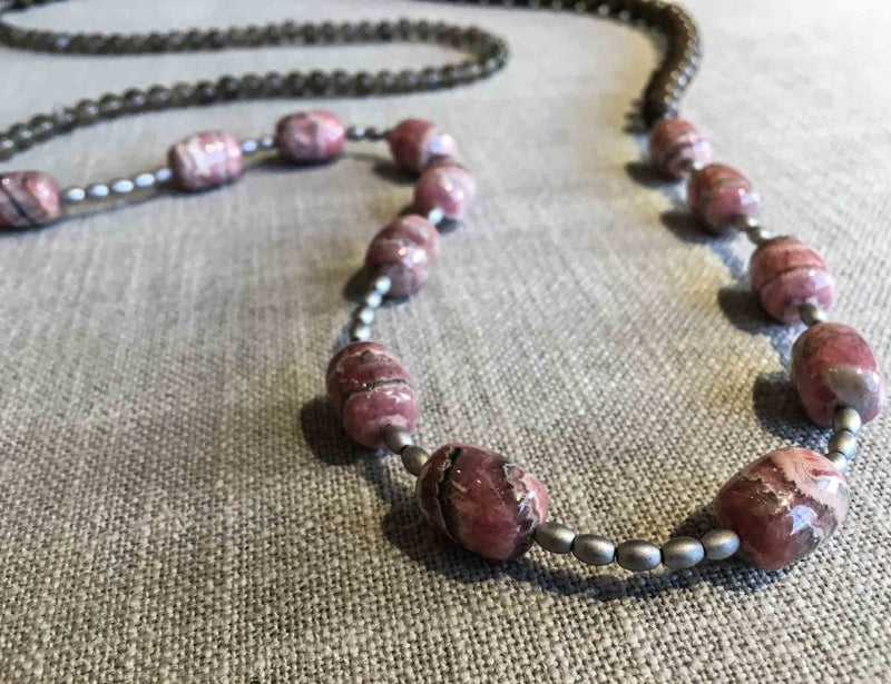 closeup of gemstone bead necklace comprising pink rhodochrosite, grey moonstone, exotic wood and silver hematite  Edit alt text