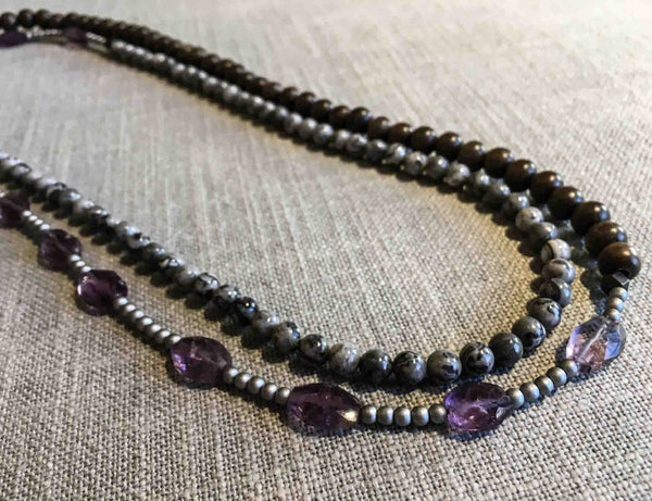 top view of gemstone bead necklace comprising purple amethyst, grey tourmalated quartz, exotic wood and matte silver