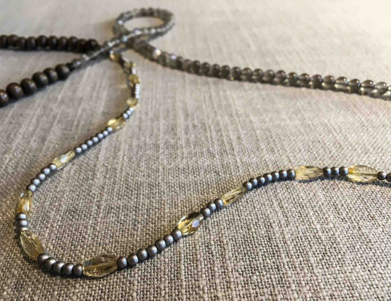 closeup of gemstone bead necklace comprising yellow citrine, grey moonstone, exotic wood and silver hematite