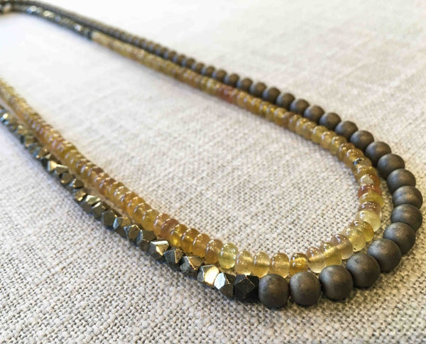 top view of gemstone bead necklace comprising yellow sapphire, dark grey pyrite and matte bronze