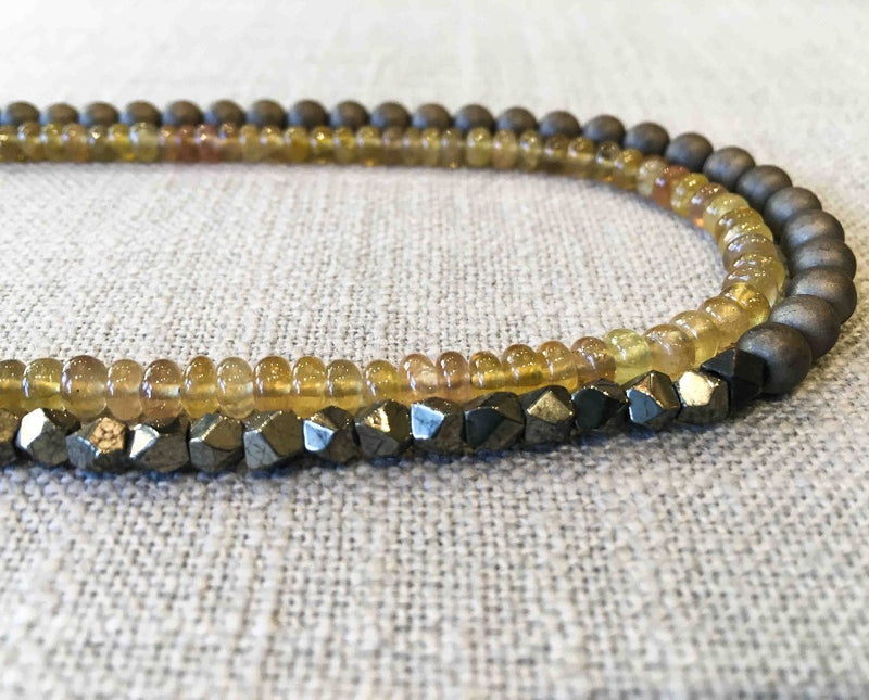 side view of gemstone bead necklace comprising yellow sapphire, metallics and bronze hematite