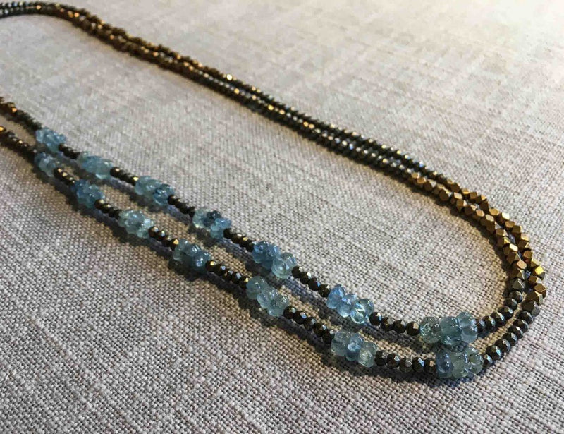 top view of gemstone bead necklace comprising light blue melon aquamarine, bronze and dark grey pyrite