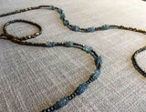 closeup of gemstone bead necklace comprising light blue melon aquamarine, bronze and pyrite