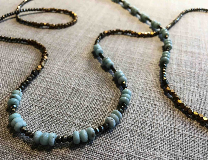 closeup of gemstone bead necklace comprising blue lace agate, bronze and pyrite