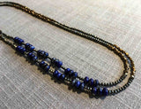 top view of gemstone bead necklace comprising dark blue lapis, bronze and dark grey pyrite