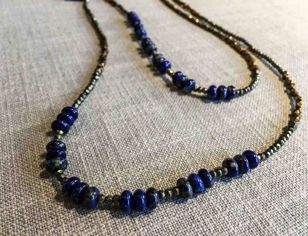 closeup of gemstone bead necklace comprising dark blue lapis, bronze and pyrite