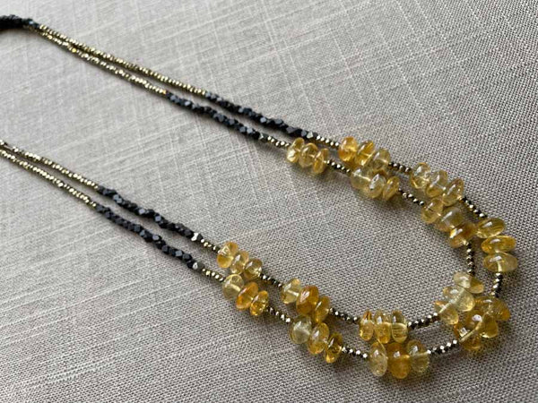 top view of gemstone bead necklace comprising yellow citrine, dark bronze and golden pyrite