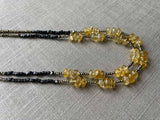 side view of gemstone bead necklace comprising yellow citrine, dark bronze and golden pyrite