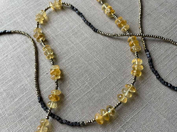 closeup of gemstone bead necklace comprising yellow citrine, dark bronze and golden pyrite