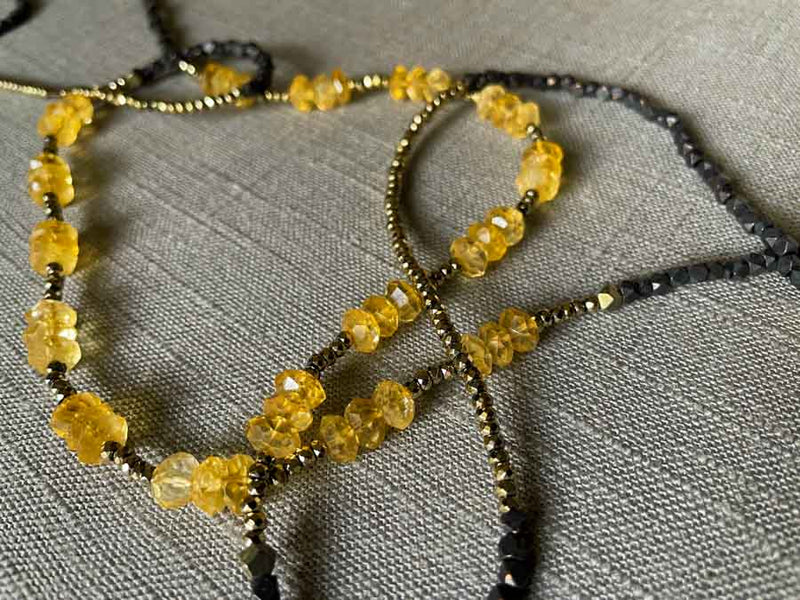 closeup of gemstone bead necklace comprising yellow citrine, dark bronze and golden pyrite