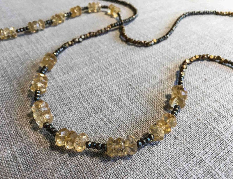 closeup of gemstone bead necklace comprising faceted yellow citrine, bronze and pyrite