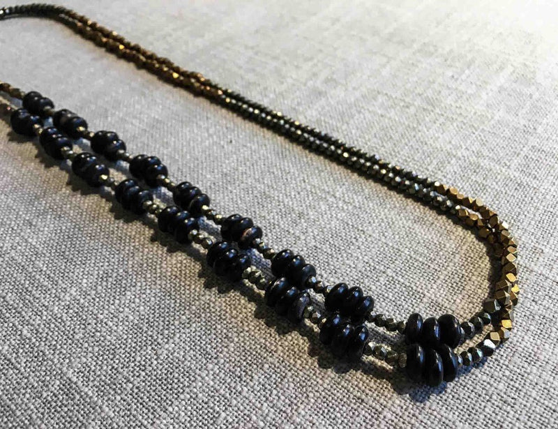 top view of gemstone bead necklace comprising black horn, bronze and dark grey pyrite