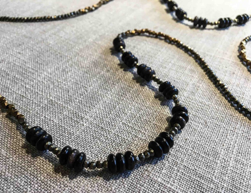 closeup of gemstone bead necklace comprising black horn, bronze and pyrite