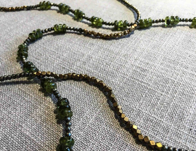 closeup of gemstone bead necklace comprising green peridot, bronze and pyrite