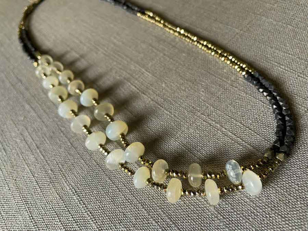 top view of gemstone bead necklace comprising white moonstone, dark bronze and golden pyrite