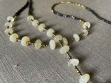 closeup of gemstone bead necklace comprising white moonstone, dark bronze and golden pyrite