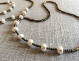 closeup of gemstone bead necklace comprising white pearl, bronze and pyrite