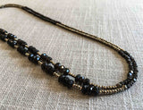 top view of gemstone bead necklace comprising dark purple smoky quartz, bronze and golden pyrite