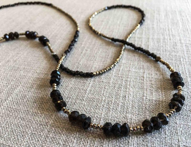 closeup of gemstone bead necklace comprising dark purple smoky quartz, bronze and golden pyrite