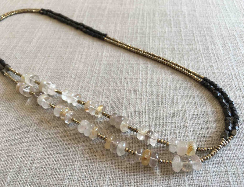 top view of gemstone bead necklace comprising yellowish white rutilated quartz, dark bronze and golden pyrite