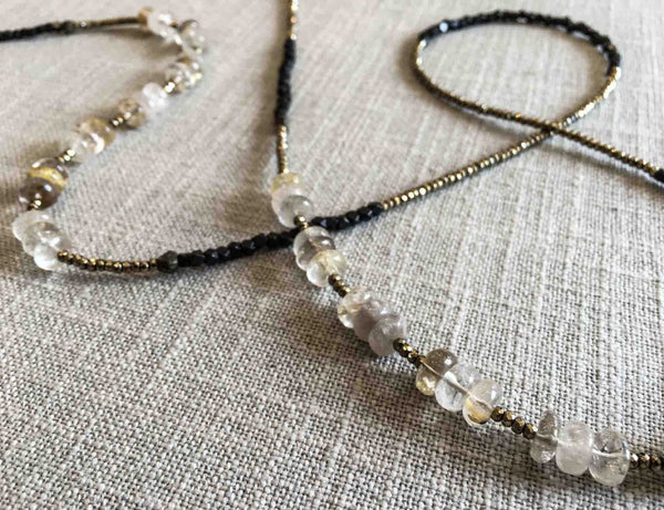 closeup of gemstone bead necklace comprising off-white rutilated quartz, dark bronze and golden pyrite