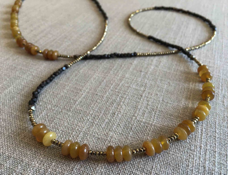 closeup of gemstone bead necklace comprising yellow jade, dark bronze and metallics