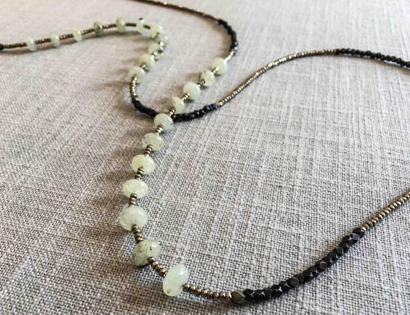 closeup of gemstone bead necklace comprising light green prehnite, dark bronze and golden pyrite