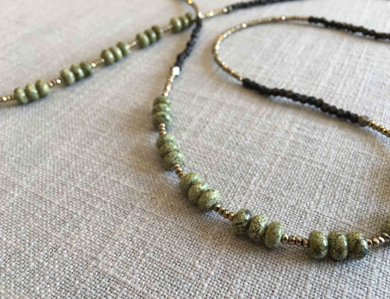 closeup of gemstone bead necklace comprising green moss agate, dark bronze and metallics