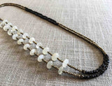 top view of gemstone bead necklace comprising white moonstone, dark bronze and golden pyrite