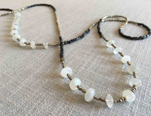 closeup of gemstone bead necklace comprising white moonstone, dark bronze and metallics