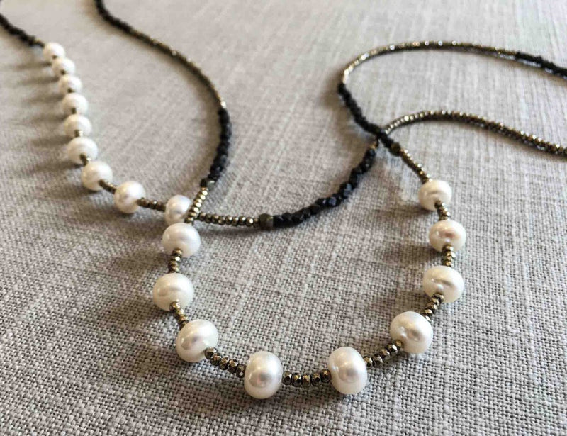 closeup of gemstone bead necklace comprising white pearl, dark bronze and golden pyrite