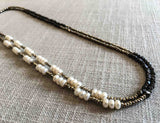 top view of gemstone bead necklace comprising white pearl, dark bronze and golden pyrite