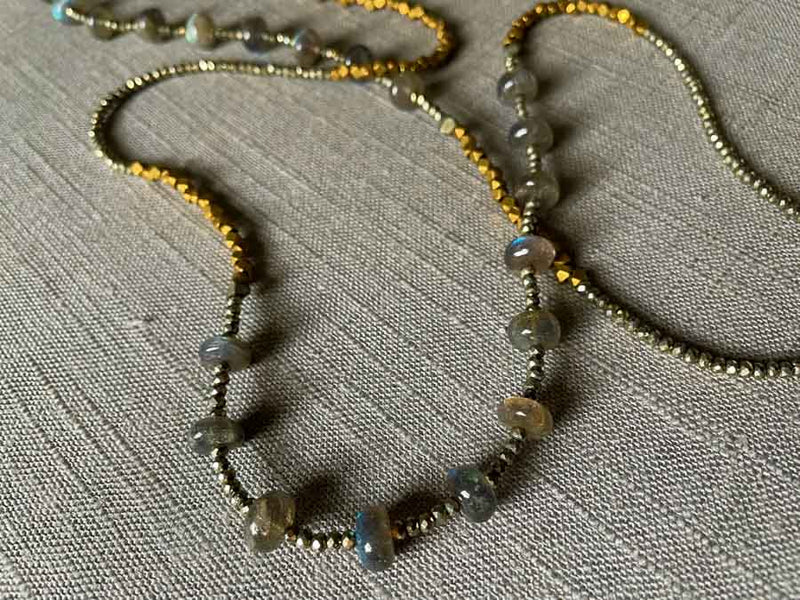 side view of gemstone bead necklace comprising blue labradorite, bronze and dark grey pyrite