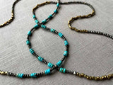 closeup of of gemstone bead necklace comprising turquoise, bronze and dark grey pyrite