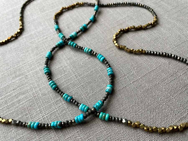 closeup of of gemstone bead necklace comprising turquoise, bronze and dark grey pyrite