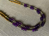 closeup of gemstone bead necklace comprising purple amethyst, bronze and dark grey pyrite