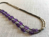 top view of gemstone bead necklace comprising purple amethyst, silver and dark grey pyrite