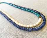 top view of gemstone bead necklace comprising turquoise, beige conch shell and blue sapphire