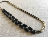 top view of gemstone bead necklace comprising black horn, silver and dark grey pyrite